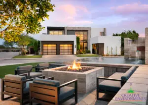 Custom front yard design with artificial turf, fire pit and metal scupper water feature into pond.