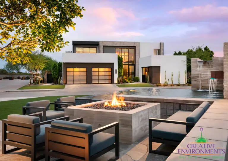 Custom front yard design with artificial turf, fire pit and metal scupper water feature into pond.