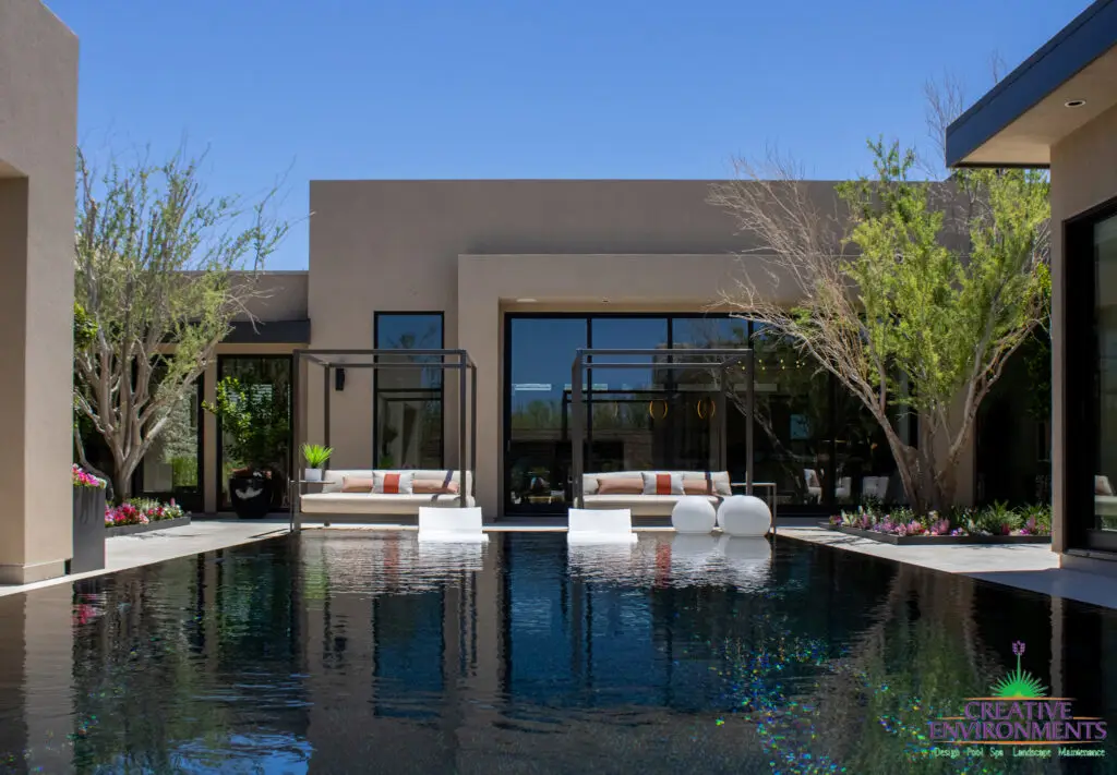 Custom backyard design with daybeds, baja step and zero-edge pool.