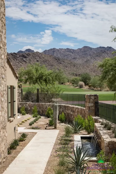 Custom backyard design with organized planting, natural stone accents and metal scupper water feature.