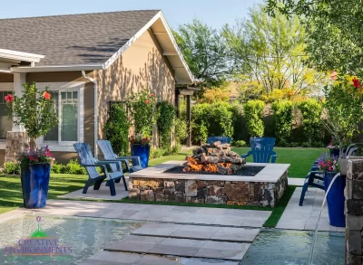 Custom square fire pit with Jesus steps, large planters and large metal trellis.