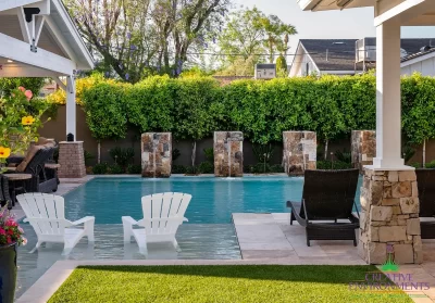 Custom backyard design with baja step, multiple seating areas and artificial turf.