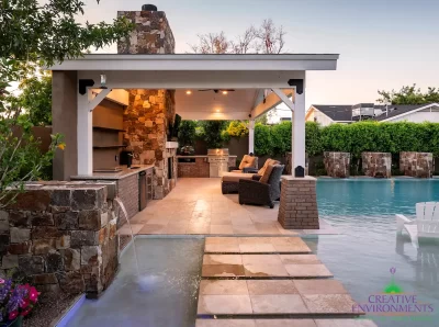 Custom backyard design with water columns, Jesus steps and floor-to-ceiling natural stone fireplace.