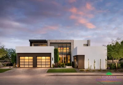Custom front yard design with artificial turf, up lighting and cacti.