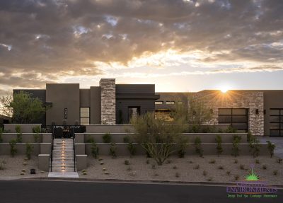 Custom front yard design with step lighting, organized planting and custom metal work.