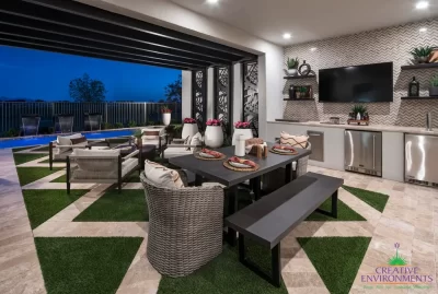 Custom backyard design with artificial turf pattern, outdoor TV and outdoor shelving.