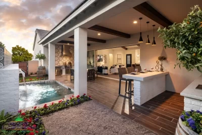 Custom backyard design with wooden ceiling beams, water feature and organized planting.