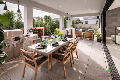 Custom backyard design with multiple seating areas, outdoor kitchen and privacy hedges.