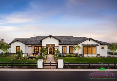 Custom front yard design with metal fencing, artificial turf and up lighting.