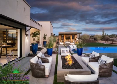Custom backyard design with blue accents, shade structure and linear fire table.