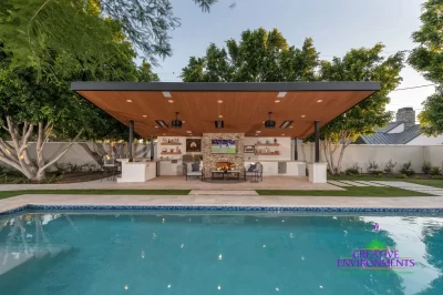 Custom backyard design with angled shade structure, travertine decking and organized planting.